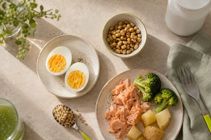 Ovos, soja, salmão, brócolis, batata e quinoa representam fontes alimentares de colina ao lado de frasco sem marca